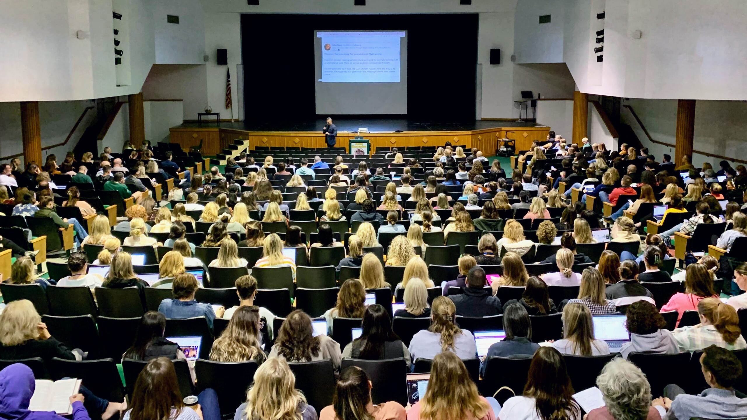 Derek speaking in front of a large crowd